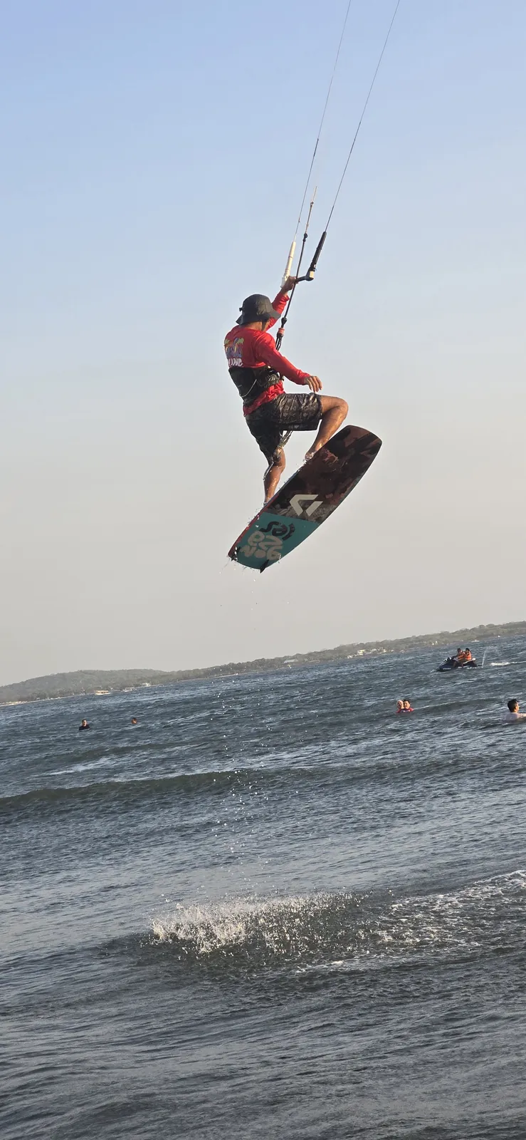 Kitesurfista volando alto sobre el agua