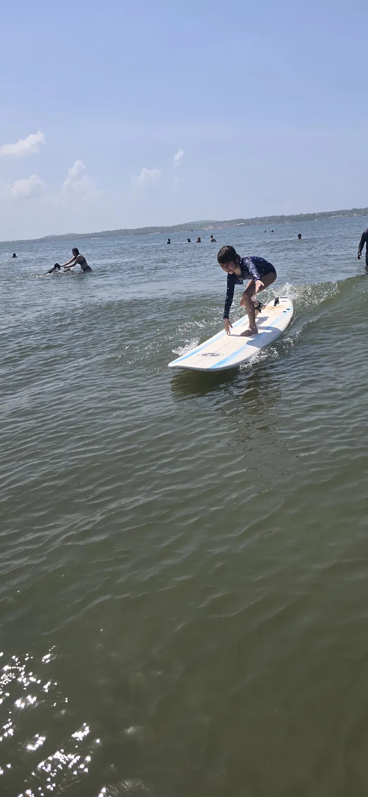 Chica haciendo popup en longboard sobre la espuma