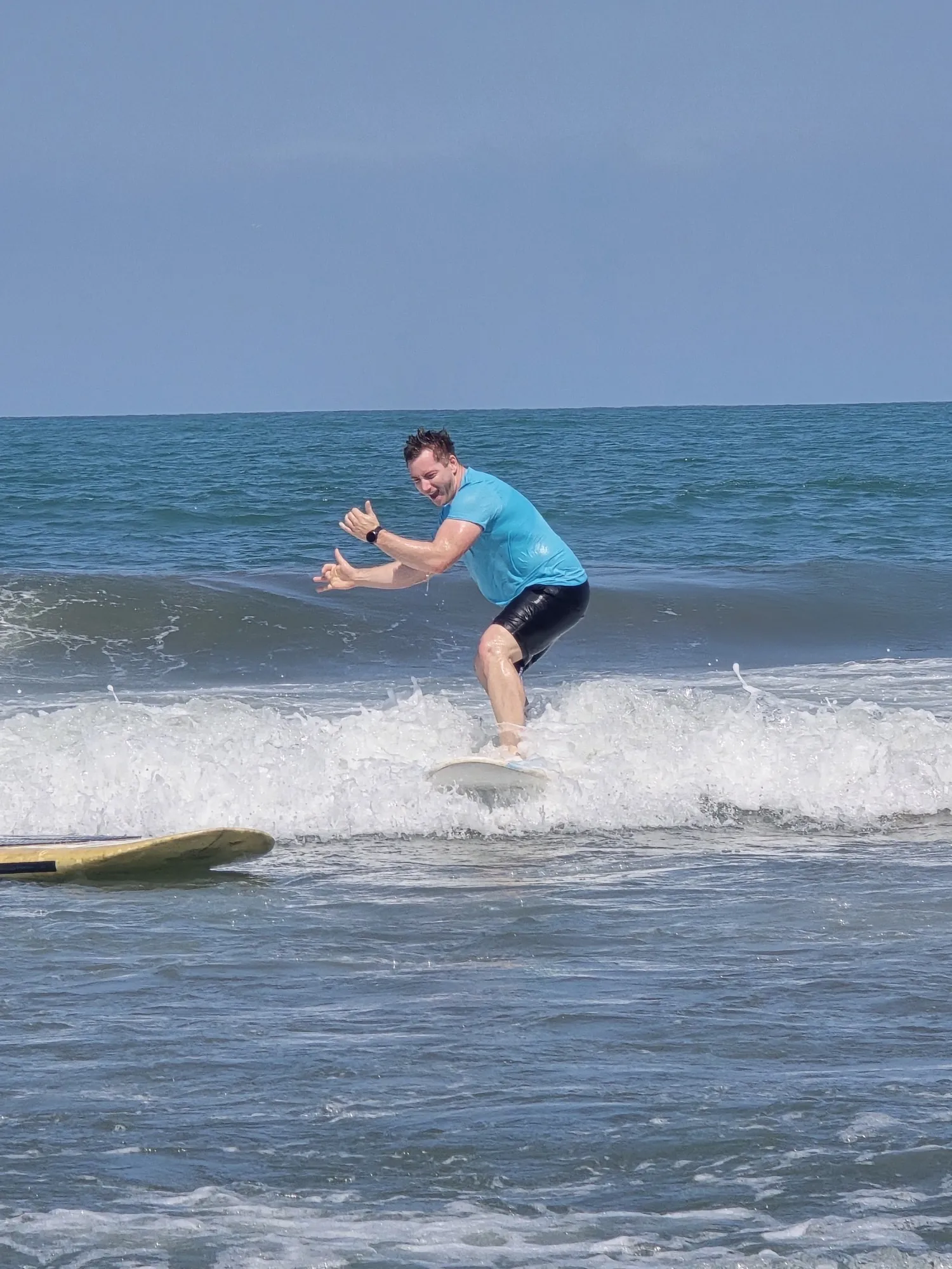 Estudiante de surf de pie sobre una ola de espuma blanca en Cartagena